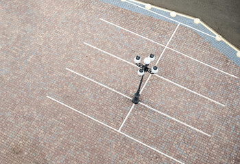 Parking for cars with white markings. Parking is paved with paving slabs.