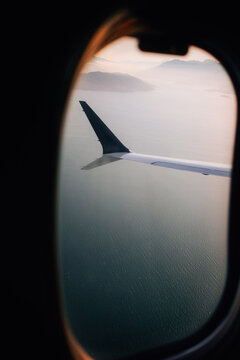 View of airplane wing over ocean through window