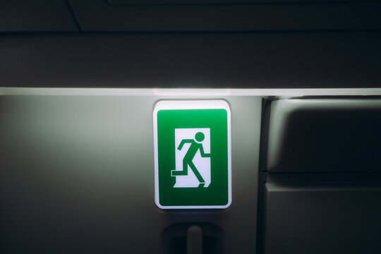 Illuminated emergency exit sign inside an aircraft cabin