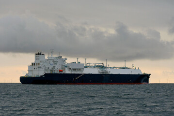 Obraz premium LNG Carrier, Liquefied Natural Gas Tanker With Offshore Wind Turbines Generators On Horizon