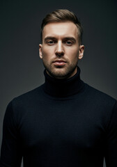 Fototapeta premium Handsome man with stylish hair and beard wears a black turtleneck sweater indoors