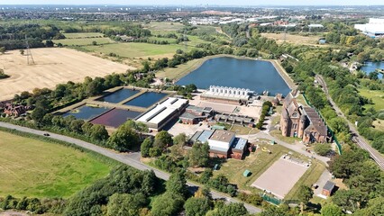 Aerial drone shot of wastewater sewage treatment plant, with storage silos and lake water, industrial removal of contaminants in Birmingham England UK