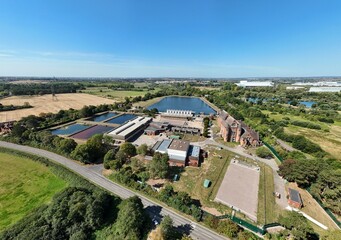 Aerial drone shot of wastewater sewage treatment plant, with storage silos and lake water, industrial removal of contaminants in Birmingham England UK
