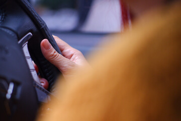 Close-up of a woman's hand holding a car steering wheel.