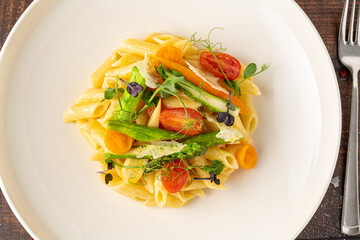 Creamy penne pasta with asparagus, cherry tomatoes and microgreens
