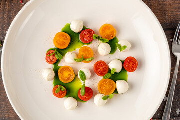 Colorful Caprese salad with cherry tomatoes, mozzarella and fresh basil