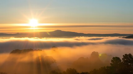 Fototapeta premium Golden sun flare breaking through morning mist above peaceful rural hills