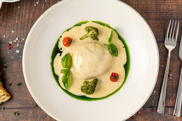 Gourmet stuffed pasta served with creamy sauce, broccoli and herbs