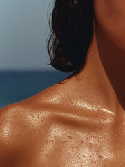 Skin glistening with tiny water droplets shines under the bright summer sun near the ocean