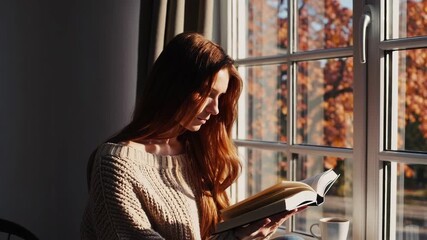 Autumn morning reading by the window: warm light, cozy blanket, relaxed ambiance