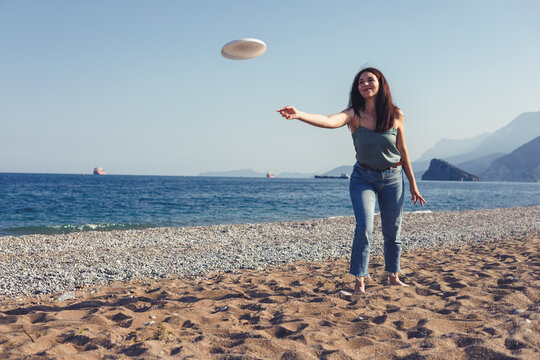 Woman playing frisbee on a sunny beach