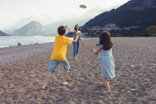 Family enjoying a frisbee game at the beach