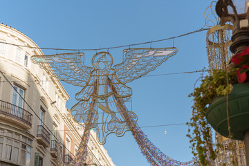Christmas ornament in the shape of an angel hanging in the city, during the day