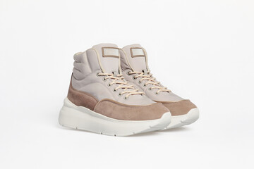 Women's fashion winter high-top sneakers with laces isolated on white background. Sports shoes for female, beige color, basketball boots, high soled boots. Luxury footwear mock up, template. Side view