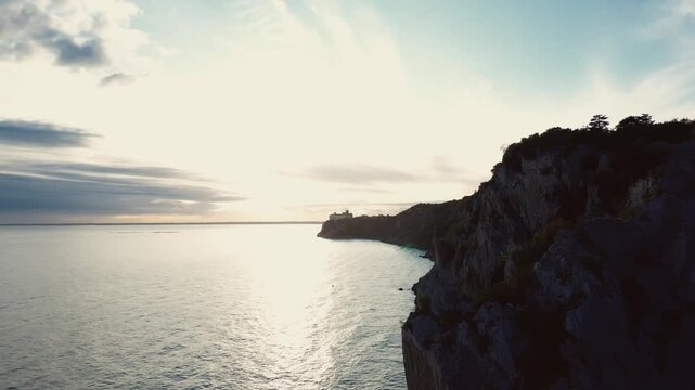 Drone is flying along the shore with huge cliffs towards Castello di Duino, 4k