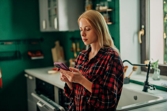 Woman completing two-factor authentication on smartphone at home