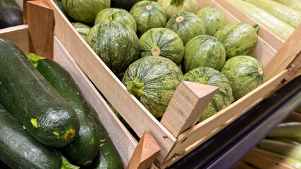 Ronde de Nice zucchinis nestle in wooden crates, evoking rustic harvest rituals and the vibrant Fete de la Courgette