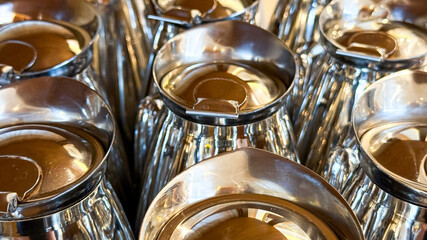 Shimmering chrome kettles, like soldierly meerkats, reflect warm amber light, perfect for Samovar tea rituals or International Coffee Day