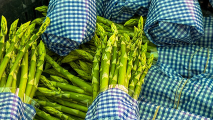Bundles of verdant asparagus nestled in checkered cloth, hint at Spring Equinox feasts and agrarian...