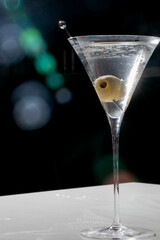 Sleek martini glass cradling verdant olive, nighttime whispers of Lunar New Year, Enotica...