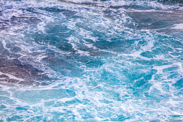 A large body of water with blue waves crashing against the shore