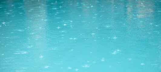 A body of water with raindrops falling on it