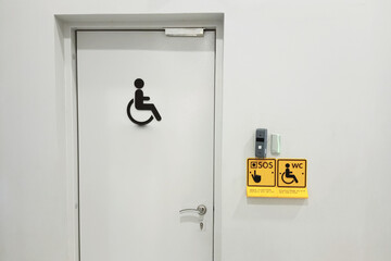 White door. Entrance to a public toilet. Sign for people with disabilities.