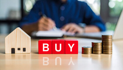 Fototapeta premium Real estate concept featuring a small wooden house, the word BUY in block letters, and stacks of coins with a person in the background. The image conveys themes of property investment.