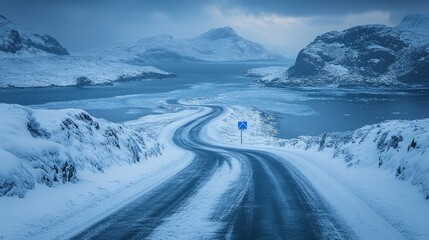 A winding road traverses a serene winter scene of snowy peaks and icy waters at twilight
