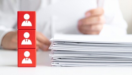 Conceptual image representing recruitment or human resources with stacked blocks with people icons. A person is holding some papers