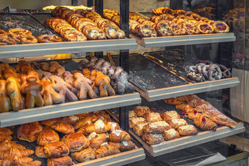 Bakery display with traditional pastries. Bakery shelves full of traditional German pastries, pretzels, sweet bread during holiday season. Concept of holiday pastry, festive baked goods, winter treats