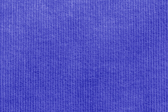 Close-up of blue corduroy trousers pants fabric background backdrop. Traditional fashion garment fabric concept.