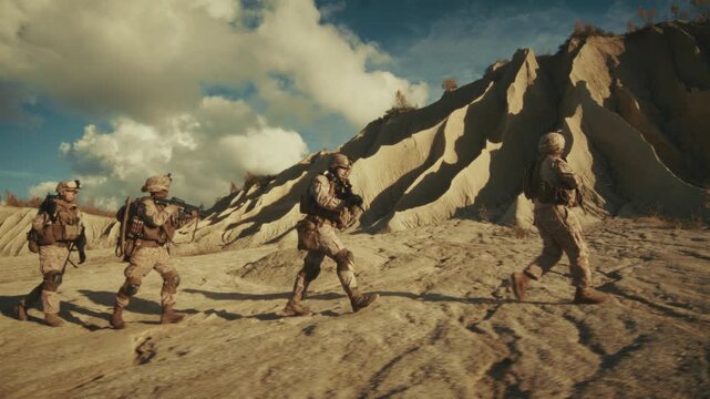 Four Soldiers in Desert Camouflage Uniforms and Tactical Gear Walk in Formation Across a Rocky, Sandy Middle Eastern Landscape Holding Rifles and Moving Cautiously on a Mission. Special Ops Operation