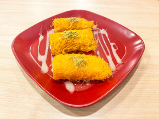 Kunafa Dessert with Pistachios and Drizzle on a Red Plate