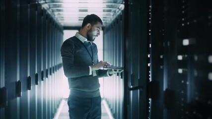 It Engineer With Beard Works on a Laptop While Inspecting Server Racks in Data Center. Advanced Digital Infrastructure, Illuminated Servers, and Secure  Cloud Computing and Big Data Management. - Powered by Adobe