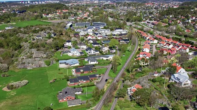 Aerial footage of Askim, a residential district south of Gothenburg, Sweden. Shows suburban houses with red and grey rooftops, roads, rocky hills, and green landscapes.