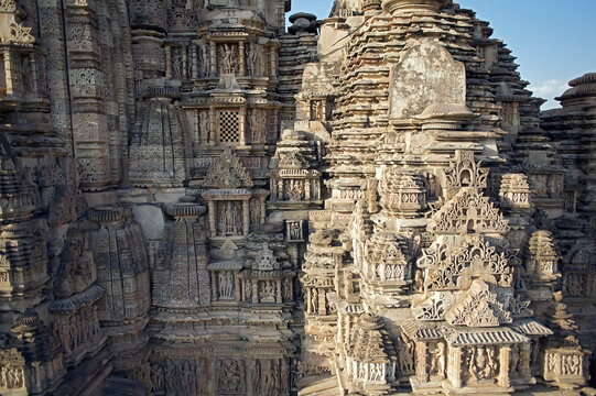Aerial view of the intricate carvings adorning the Khajuraho temples, their weathered stone surfaces bathed in the warm glow of the sun, Khajuraho, Madhya Pradesh, India.