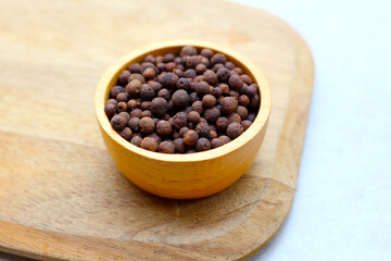 Brown dried allspice spice seeds.