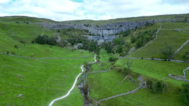 Malham Cove in the North Yorkshire Dales in the north of England. Malham Cove is a large curved limestone formation formed by a waterfall carrying meltwater from glaciers in the last Ice Age
