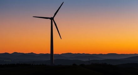 Wind turbine silhouette against sunset landscape