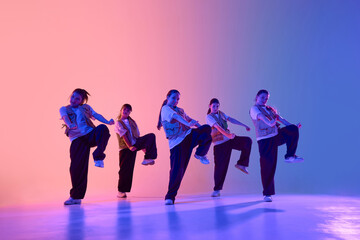 A vibrant urban dance crew, consisting of diverse young adults, expresses creativity and unity through energetic movement. Concept of teamwork and expression in street culture.