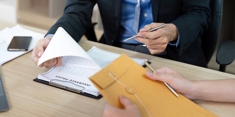 Insurance Policy Discussion. Businessman presenting documents to client in office.