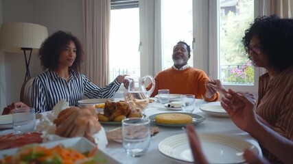 Storytelling image of a Family reunited at parents house for lunch on the holidays. Family members celebrating at home eating good food, sharing love and positive emotions - Powered by Adobe