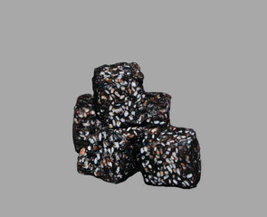 A Detailed Studio Close-up of a Small Stack of Three Dark, Rustic Cubes, a Healthy Snack Made from a Rich