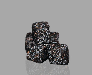 A Detailed Studio Close-up of a Small Stack of Three Dark, Rustic Cubes, a Healthy and Natural Snack Made from a Rich