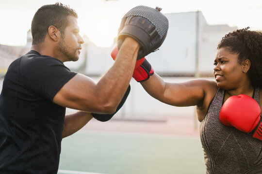 Curvy african american girl and her personal trainer doing sport workout session outdoor - Sport, diet and healthy lifestyle concept - Main focus on woman face