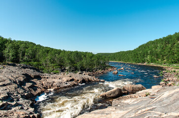 streams of clear waterfall water and stone banks of a mountain river