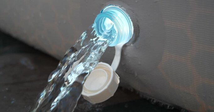 Water drains from a frame pool. Draining water from outdoor open-air swimming pool