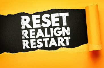 Bold white grunge text “RESET REALIGN RESTART” revealed on a black background beneath torn yellow paper. Concept for personal growth, productivity reboot, goal setting, and fresh starts