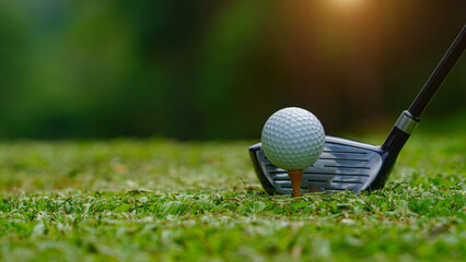 Golf clubs and balls on a green lawn in a beautiful golf course with morning sunshine.